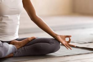 Person sitting on a yoga mat, posing