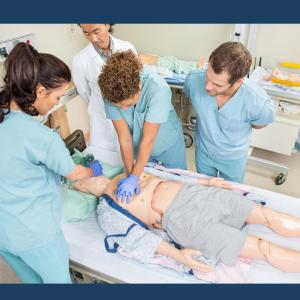 Student nurses gathered around a simulated patient