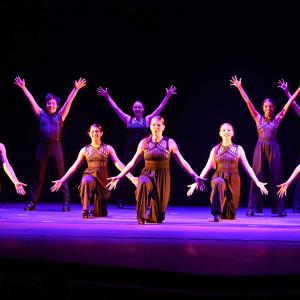 Students performing a dance routine on stage