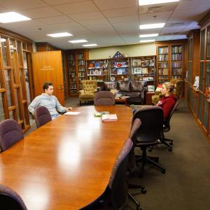 Two students sitting in the NHIOP political library