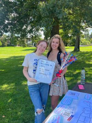 Two students showing the reason why they registered to vote