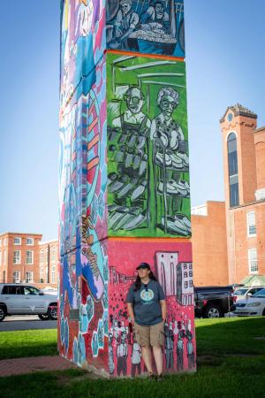 Jyl Dittbenner ’97 standing next to one of her murals