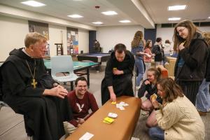 Abbot Mark Cooper, O.S.B. ’71 playing a card game with students