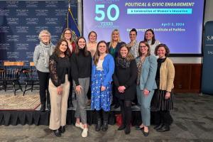 Attendees and panelists pose for a group photo in the NHIOP Auditorium at the "Women in the Public Square" event