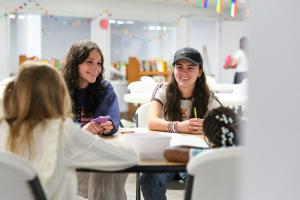 Students sitting with students in the Saint Raphael Community Center