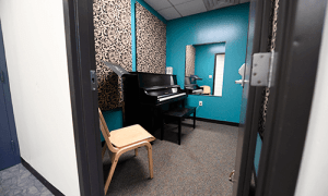 A practice room with a chair and a piano