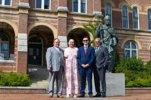 President Favazza standing with Diego Benites and his family in front of Alumni Hall