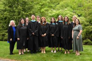 Graduates of the Special Education M.Ed. program posing in gowns with faculty members on the lower quad