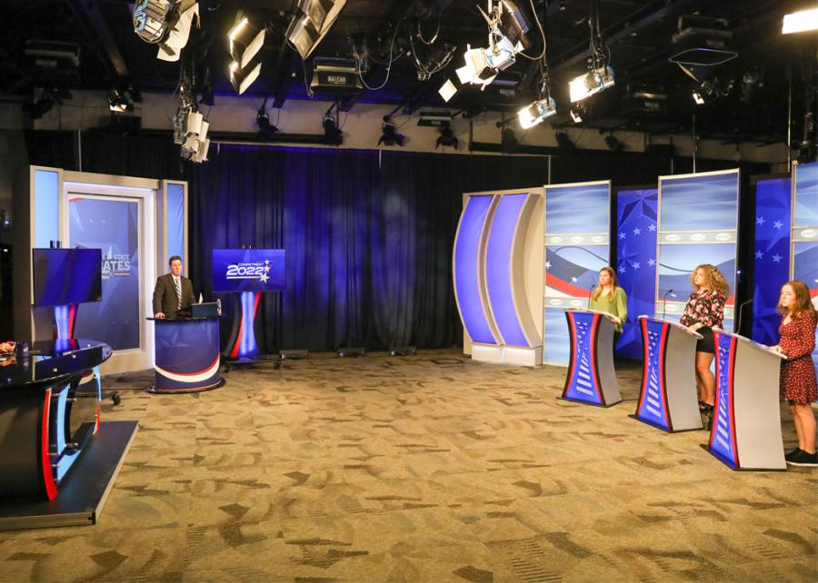 Students stand at podiums for debates.