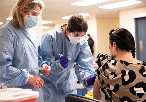 Student nurse giving covid vaccine